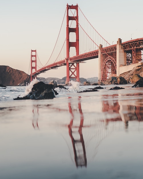 Vertical shot of the golden gate bridge under a cloudy sky