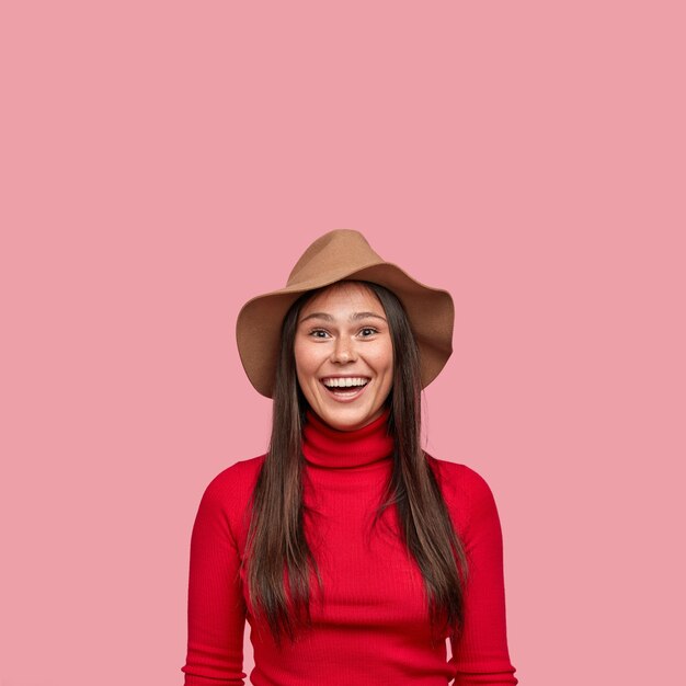 Vertical shot of good looking cheerful smiling girl has long straight hair