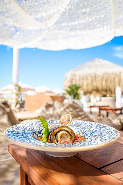 Vertical shot of a gourmet fish dish at a beachside restaurant