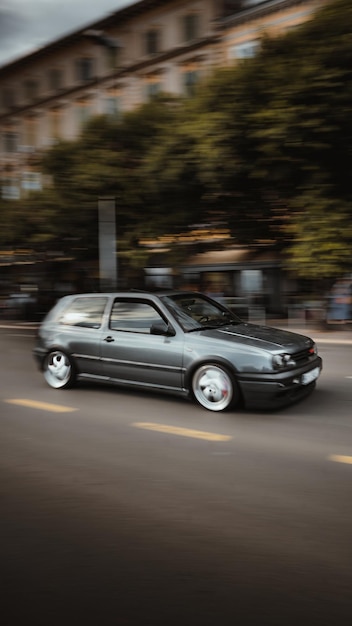 Vertical shot of a gray car driving down the road with long exposure