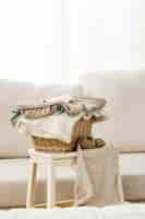 Free photo vertical shot of a gray sofa with a basket of folded clothes on a small table near it