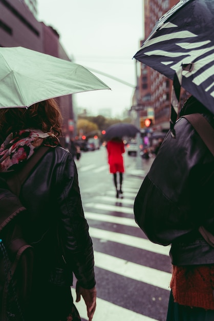 雨の下で通りを歩いている人々のグループの垂直ショット