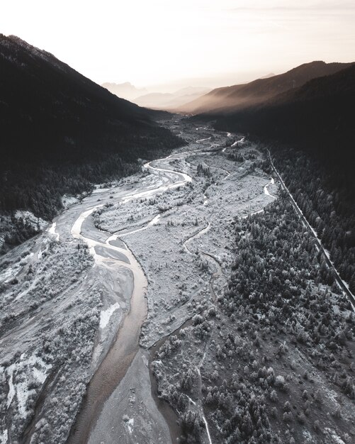 Vertical shot of half-frozen river flowing through the mountains