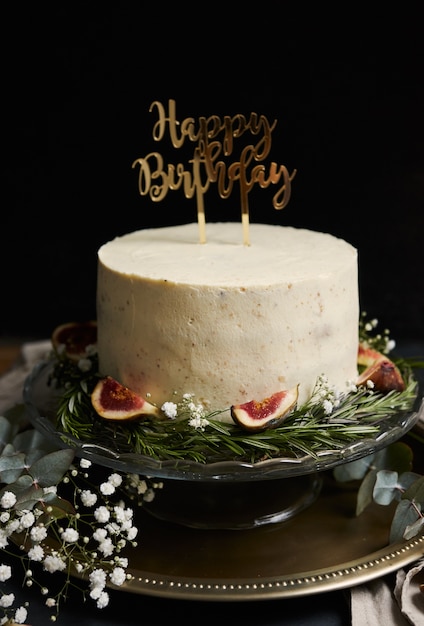 Foto gratuita colpo verticale di una torta di sogno di buon compleanno con crema bianca sul nero