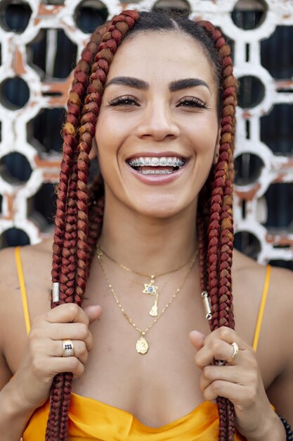 Vertical shot of a Hispanic woman with braids smiling