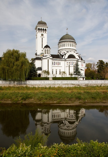 Вертикальный снимок собора Святой Троицы, отражающегося в озере в Сигишоара, Румыния