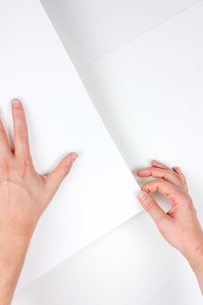 白と一枚の白い紙を保持している人間の手の垂直方向のショット