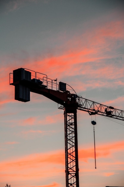 Ripresa verticale di una gru da costruzione industriale durante il tramonto