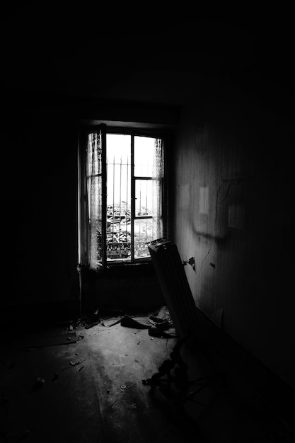 Vertical shot of the inside of a ruined toom with a damaged heater on a black background