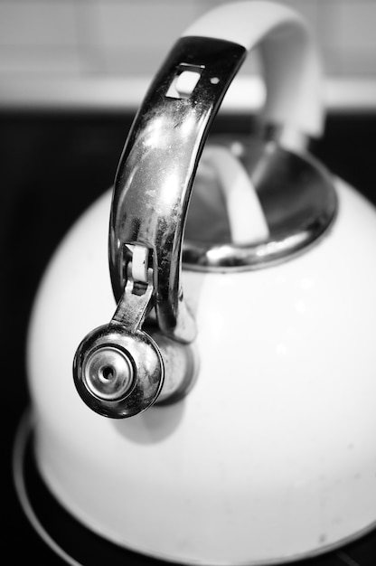 Vertical shot of a kettle on the stove in the kitchen