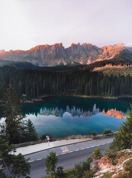 Foto gratuita ripresa verticale del lago di carezza circondato dalle dolomiti e dal verde in alto adige italia