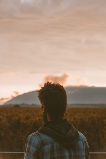 Vertical shot of a lonely person enjoying the beautiful view of the sunset