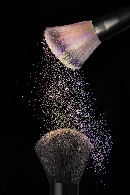 Vertical shot of makeup brushes on black surface
