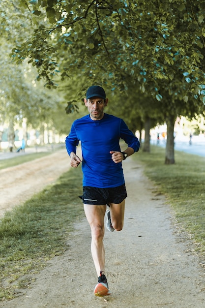 Free photo vertical shot of a man running in the street - a healthy lifestyle