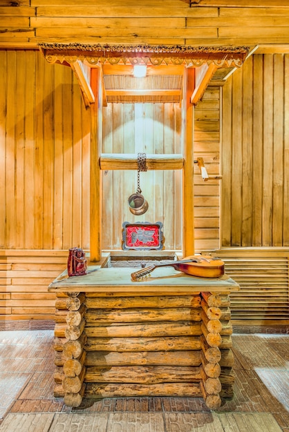 Vertical shot of a mandola on a wooden table with a wooden wall