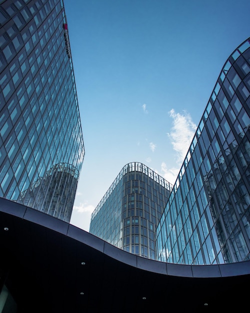 Vertical shot of modern office buildings with big reflective windows under the sunlight