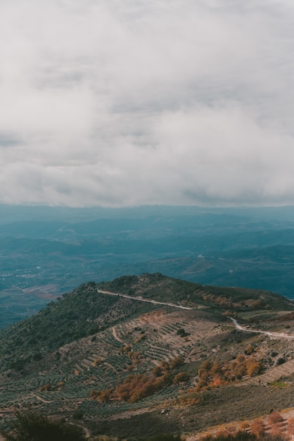 Vertical shot of a mountain under a cloudy sky