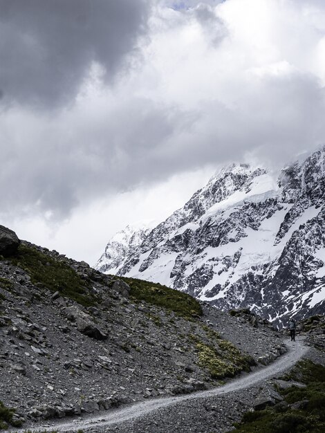 Vertical shot of a mountain pathway on grey clouds