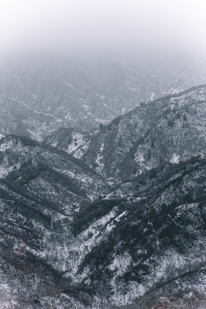 Vertical shot of mountains covered with white snow during winter