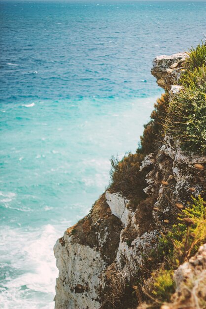 Vertical shot of the ocean seen from a cliff during daytime