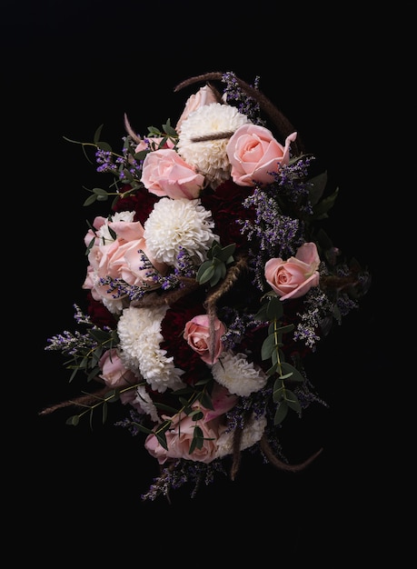 Бесплатное фото Вертикальный снимок роскошного букета из розовых роз и белых, красных георгинов на черном