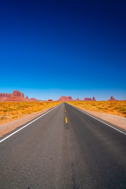 Бесплатное фото Вертикальный снимок пустой дороги в окружении ландшафта