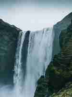 Бесплатное фото Вертикальный снимок водопада скоугафосс в исландии в пасмурный день