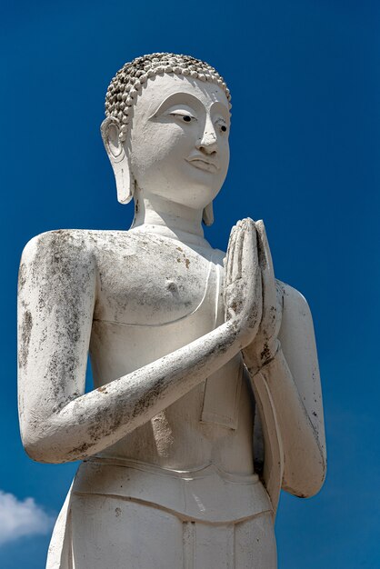 澄んだ青い空と古い仏像の垂直ショット