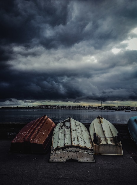 Vertical shot of old fishing boats turned upside down under the gloomy sky