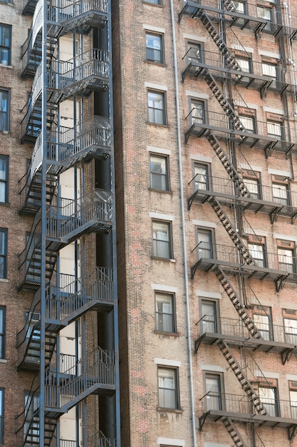 Vertical shot of old stone apartment buildings with fire exit staircases on sides