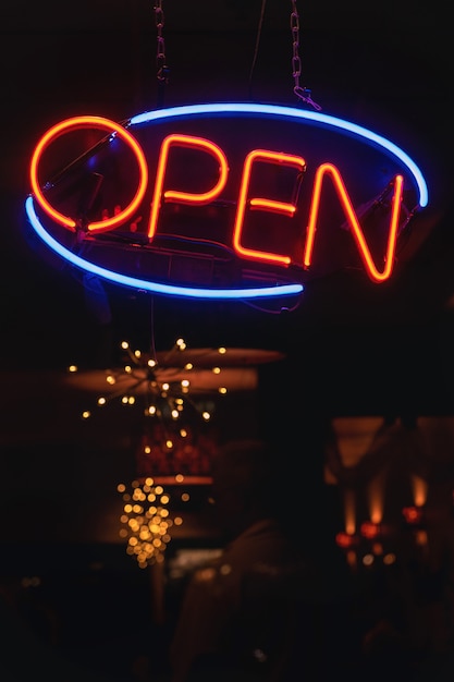 Free photo vertical shot of an orange and blue neon sign that says 