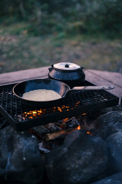 Vertical shot of a pan and kettle on the grill