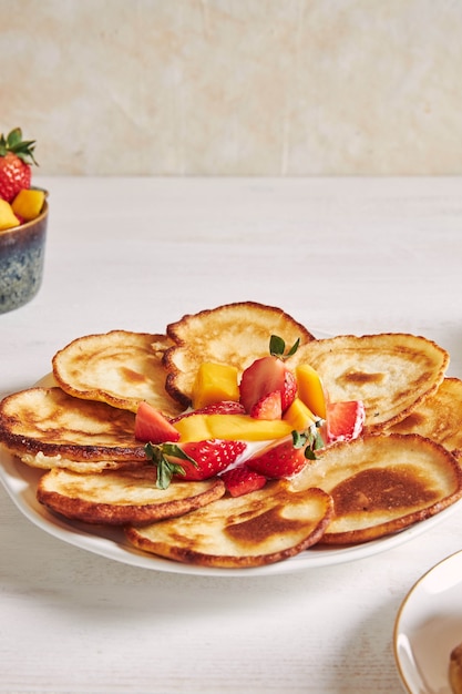 Vertical shot of pancakes with fruits on the top