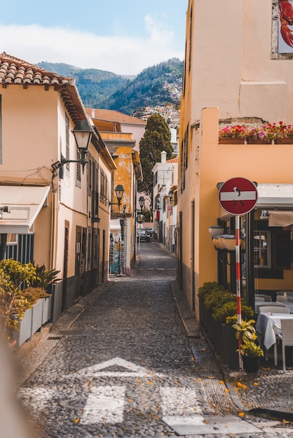 Vertical shot of a pathway in the middle of buildings in Funchal, Madeira, Portugal.