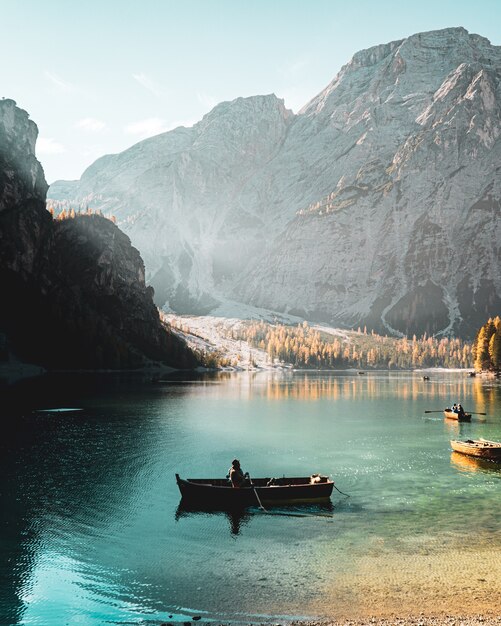 Вертикальный снимок человека, плывущего под парусом в Parco naturale di Fanes-Sennes-Braies Prags, Италия