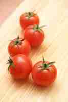 Free photo vertical shot of resh tomatoes on a wooden board