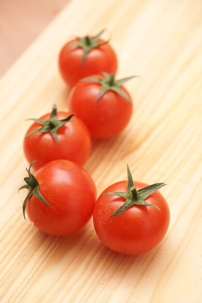 Vertical shot of resh tomatoes on a wooden board