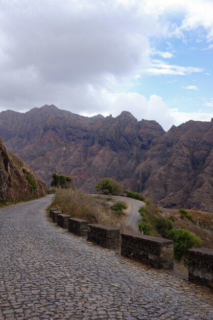 Vertical shot of a road in the middle of rock formations under the cloudy sky