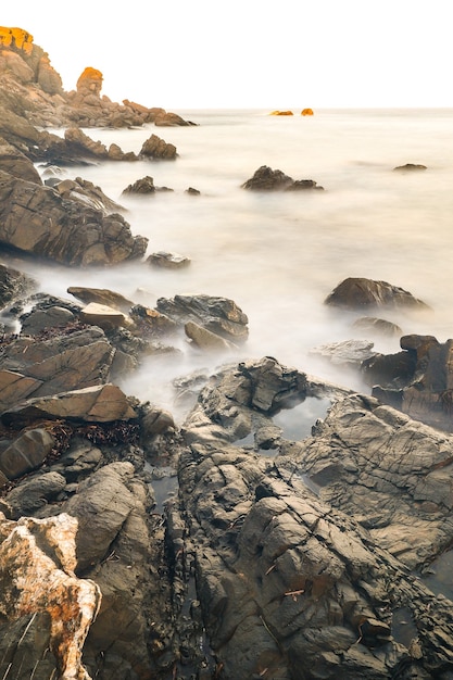 Vertical shot of rocks immersed into the ocean in vapour form in Menorca. Islas Baleares. Spain