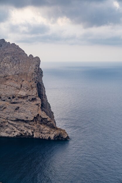 Vertical shot of the rocky cliffs over the Mallorca Mediterranean Sea captured in Spain