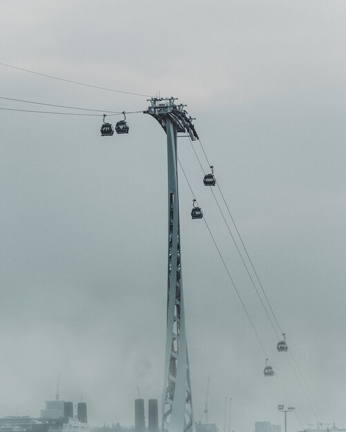 Vertical shot of ropeway on a foggy day