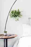 Free photo vertical shot of a round brown side table beside a bed