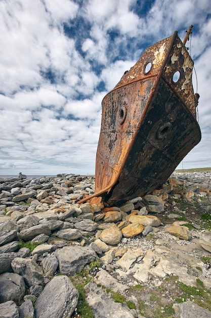 Foto gratuita colpo verticale di una carcassa arrugginita della nave plassy nelle isole aran, irlanda