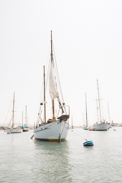Vertical shot of a sailboat in Newport Harbor, California