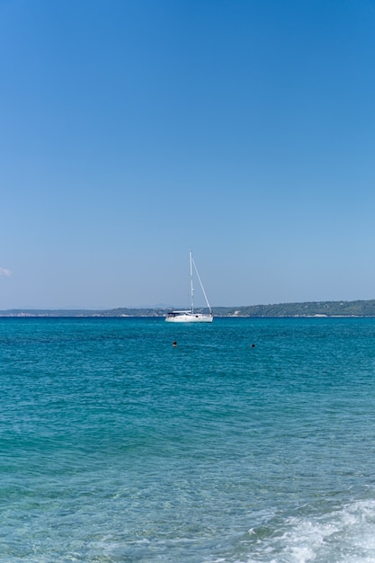 Free photo vertical shot of a sailboat in the sea
