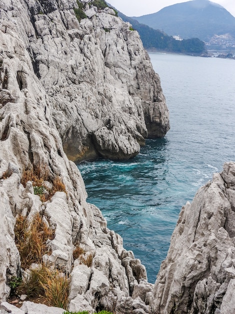 A vertical shot of Sandanbeki Cliffs surrounded by the sea in Japan