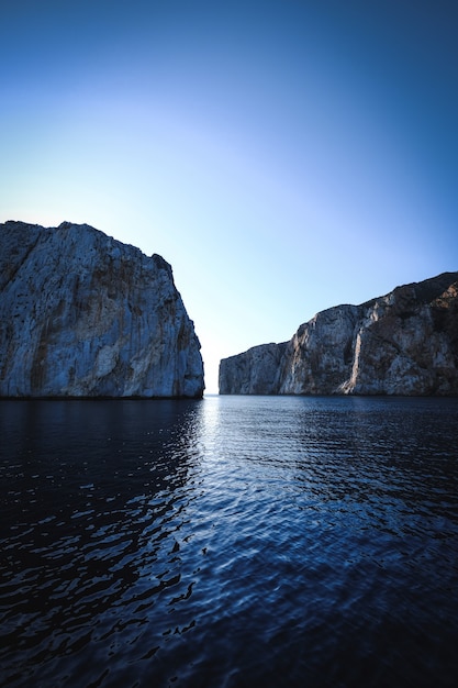 Vertical shot of a sea with cliffs in the background