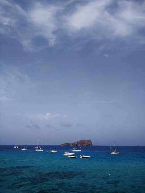 Vertical shot of the sea with several boats floating in it near Ibiza, Spain