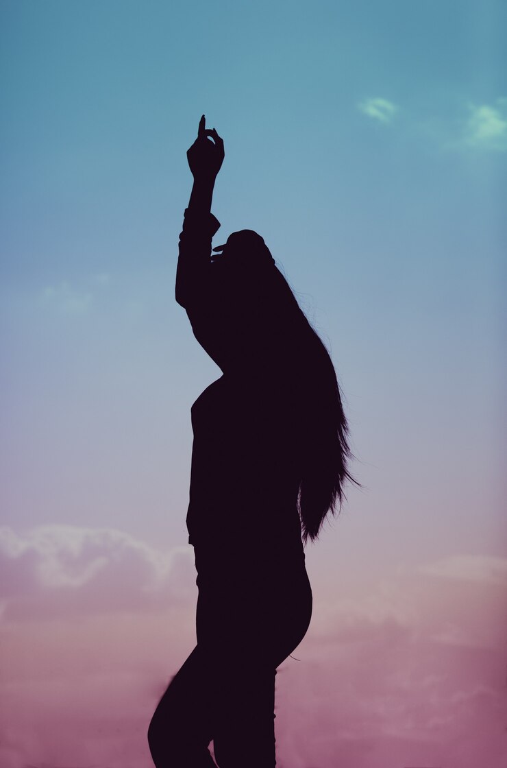 Free Photo vertical shot of a silhouette of a female dancing during a beautiful sunset