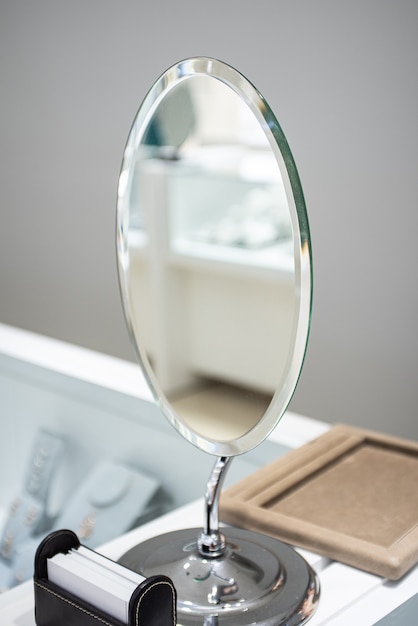Vertical shot of a silver mirror on a dresser